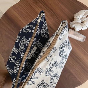 Detail of navy and beige canvas pouches with giraffe prints and simple wish tags
