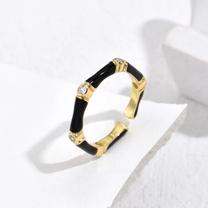French style gold plated bamboo ring with black enamel and zircons on a marble base