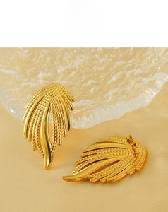 Détails des boucles d'oreilles dorées en forme d'ailes avec texture fine et finition polie