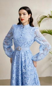 Detailed close-up of intricate lace texture and metallic buckle belt on light blue dress