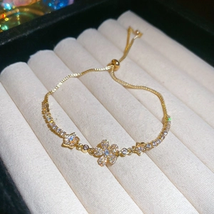 Macro detail of gold flower and star bracelet with cubic zirconia in a velvet box