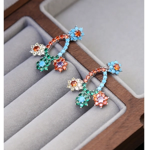 Detailed close-up of vibrant multicolored floral drop earrings with sparkling crystals