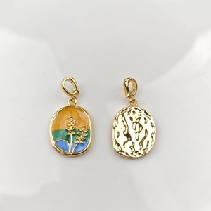 Macro detail of oval enamel pendant with golden wheat ear pattern and hammered metal texture