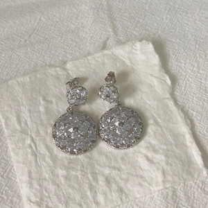 Detail of silver drop earrings featuring pavé set round and marquise cubic zirconia