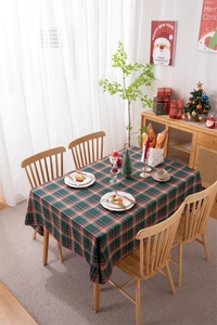 Christmas red plaid tablecloth with gold silk details and fringe on a decorated dining table