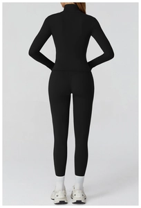 Rear view of sleek black slim-fit yoga jacket and matching high-waisted gym leggings
