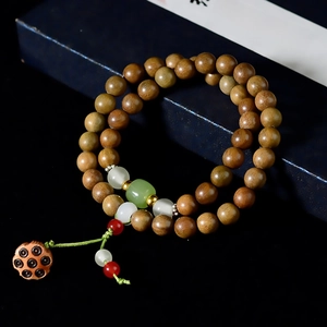 Detail of wooden double-loop bracelet with sandalwood beads and carved lotus pendant