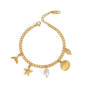 Detailed macro of gold ocean-themed stainless steel charm bracelet with pearls
