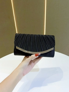 Close-up of black pleated evening clutch bag with elegant silver metallic trim detail