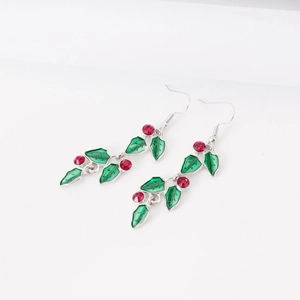 Christmas holly leaf drop earrings with green enamel and red crystals on white background