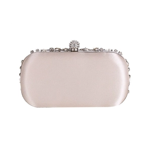Detail of champagne satin clutch featuring a luxury rhinestone and pearl encrusted closure