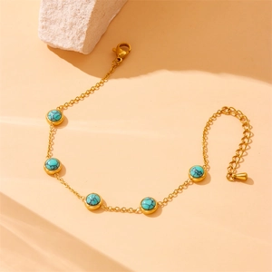 Vintage gold chain bracelet with five round turquoise stones for women on stone display
