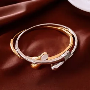 Elegant gold and silver oval crossover bracelets with white round inlay on silk