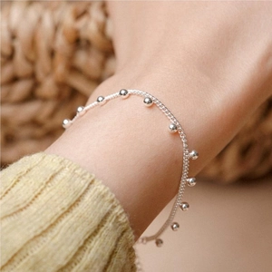 Close-up of S925 sterling silver beaded bracelet on a wrist with a warm soft atmosphere