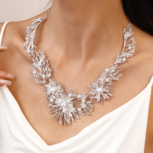 Chunky silver metallic branch necklace with faux pearls worn on neck for a bold look