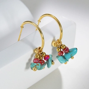 Detail of 14k gold C-shaped hoop earrings with turquoise and faceted red crystal beads