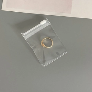 Detail of a golden open ring stored in a thick transparent EVA anti-oxidation jewelry pouch