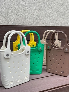 Waterproof EVA tote bags with hole design shown in five colors on wooden floor