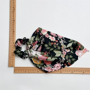 Floral satin scrunchie scarf with black base and flower patterns on white background