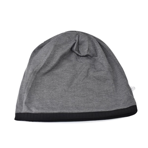 Dettaglio del berretto in maglia grigia con bordo nero a coste e design bicolore