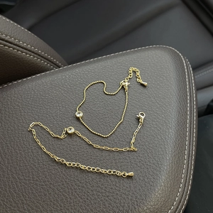 Detail of 18k gold plated paperclip and bead chains with round cubic zirconia stones