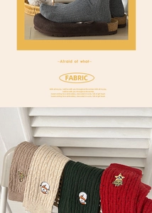 Detailed knit texture of Christmas socks featuring festive embroidery and thick twist patterns