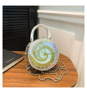 Detail of round handbag with clock pattern, metallic finish and silver chain strap