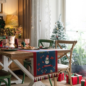 Blue Christmas snowman table runner with red tassels and Happy Holidays festive pattern