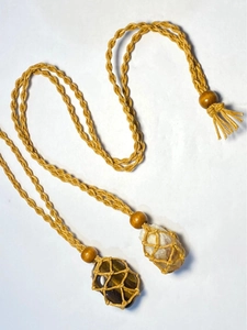 Detailed macro view of handmade woven gold cord necklaces with natural tiger eye stones