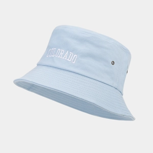 Dettaglio del cappello a secchiello azzurro con ricamo Colorado bianco e occhielli in metallo