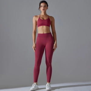 Seamless dark red yoga set featuring cross-back sports bra and high-waist gym leggings