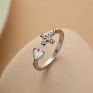 Macro shot of silver adjustable ring featuring a pavé zircon cross and a polished heart