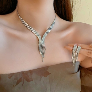 Close-up of sparkling rhinestone water drop tassel necklace and earrings set on model