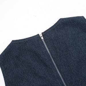 Close-up of deep blue denim fabric with silver metal zipper detail on the top