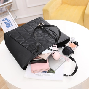 Black quilted leather tote bag with large capacity showing daily essentials inside