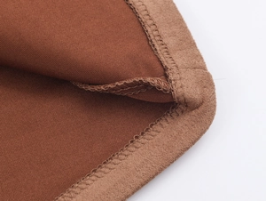 Macro detail of brown faux suede fabric with precise double-needle stitching and texture