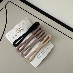 Set of four matte hollow hair clips in coffee shades displayed on a card