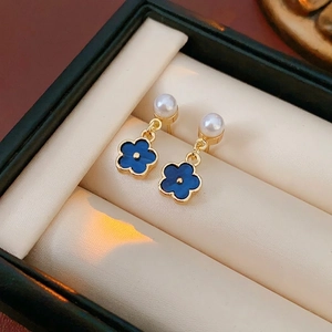 Elegant gold flower drop earrings with pearls and blue enamel in a luxury jewelry box