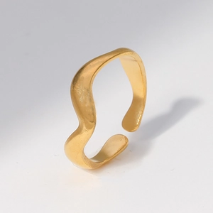Detailed close-up of golden wave-shaped adjustable stainless steel ring with matte texture