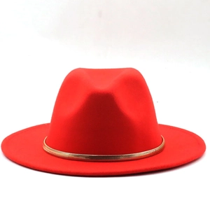 Detailed shot of a vibrant red fedora hat featuring a stylish gold snake chain decoration
