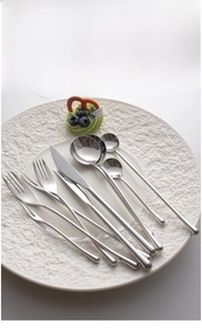 Close-up of polished 304 stainless steel flatware set neatly arranged on a ceramic plate
