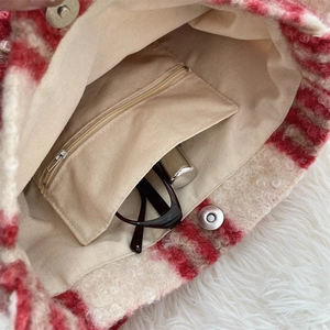 Detailed interior of red and beige checkered plush tote bag with inner zipper pocket