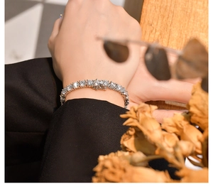 Detail eines funkelnden 925er Silber Tennisarmbands mit Zirkonia am Handgelenk des Models