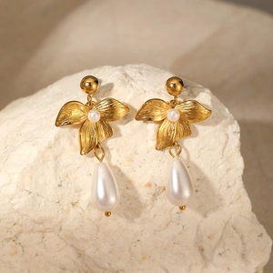Detail of gold flower earrings with brushed metal petals and teardrop pearl drops