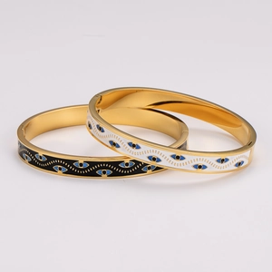 Stack of gold enamel evil eye bangles in black and white minimalist retro design