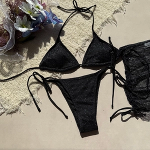 Détail à plat d'un bikini 3 pièces noir scintillant avec paréo en maille assorti