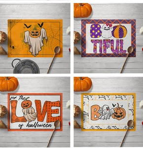 Detail of Halloween linen placemats featuring pumpkin, ghost and bat designs for dining tables