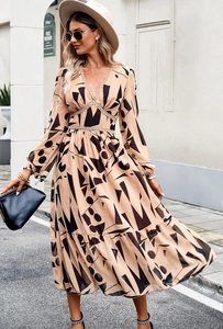 Chic long-sleeved V-neck dress with abstract geometric print and lace detail on a street setting