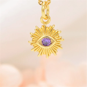 Macro detail of golden sunflower pendant necklace featuring a central purple zircon stone