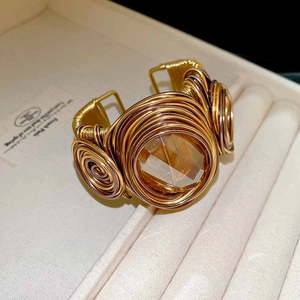 Vue macro détaillée du bracelet tressé torsadé avec une grande pierre de cristal ambré